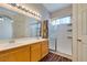 Bright bathroom with a large mirror, double vanity, and shower-over-tub with sliding glass doors at 3336 Hidden Ridge St, Las Vegas, NV 89129