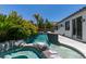 A swimming pool area with spa, pool and privacy landscaping, with a view of the side of the house at 3336 Hidden Ridge St, Las Vegas, NV 89129