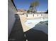 Side angle of a backyard swimming pool surrounded by a concrete patio and partial fencing at 3480 E Hacienda Ave, Las Vegas, NV 89120