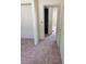 Hallway with neutral carpeting and a view through open doorways at 3601 Valley Forge Ave, Las Vegas, NV 89110