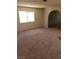 Spacious living room with large window, carpet flooring and arched doorway at 3601 Valley Forge Ave, Las Vegas, NV 89110
