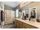 Bathroom features a double sink vanity, framed mirrors, and patterned shower curtain at 3609 Indigo Flower St # 1, North Las Vegas, NV 89084