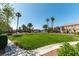 Well-maintained common area with lush green lawn and mature palm trees at 3609 Indigo Flower St # 1, North Las Vegas, NV 89084