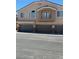 Exterior view of townhome with gray garage doors, second story balcony and neutral stucco finish at 3609 Indigo Flower St # 1, North Las Vegas, NV 89084