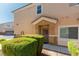 Exterior view of a townhouse entrance with a decorated front door and manicured bushes at 3609 Indigo Flower St # 1, North Las Vegas, NV 89084