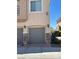 View of the garages attached to the condos with gray garage doors and stone veneer on the side columns at 3609 Indigo Flower St # 1, North Las Vegas, NV 89084