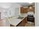 Traditional kitchen featuring stainless steel appliances, breakfast bar, wood-grain cabinets, and a double sink at 3609 Melonies Dr # 93, Las Vegas, NV 89103