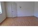 Hardwood floors throughout an empty living room, with a single window to the left of a door at 3797 Monument St, Las Vegas, NV 89121