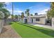 This backyard features lush artificial grass, a block wall, and mature palm trees at 3849 Boca Chica Ave, Las Vegas, NV 89120