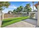 This backyard features lush artificial grass, a block wall, and a concrete patio next to a sunroom at 3849 Boca Chica Ave, Las Vegas, NV 89120
