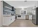 Modern kitchen featuring white cabinets, stainless steel appliances, granite countertops and floating shelves at 3849 Boca Chica Ave, Las Vegas, NV 89120
