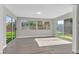 Bright sun room featuring gray wood floors, windows, and glass sliding doors to backyard at 3849 Boca Chica Ave, Las Vegas, NV 89120