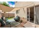 Backyard patio seating with sun shade, an artificial lawn, and a sliding glass door at 4249 Fleet Dancer St, Las Vegas, NV 89129