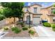 Charming two-story home with stucco exterior, a blue front door, desert landscaping, and attached garage at 4249 Fleet Dancer St, Las Vegas, NV 89129