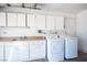 Convenient laundry area with washer, dryer, sink, and ample storage cabinets, offering functionality and organization at 4409 Rosebank Cir, Las Vegas, NV 89108