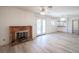 Open living space with a fireplace, French doors to backyard, with light colored, wood look floors at 4409 Rosebank Cir, Las Vegas, NV 89108