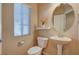Small powder room featuring a pedestal sink, toilet and decorative round mirror at 4535 Mission Meadow Cir, Las Vegas, NV 89139