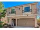 A two-story home with a beige exterior, complemented by two balconies and a two-car garage at 4535 Mission Meadow Cir, Las Vegas, NV 89139