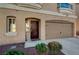 A home facade with an arched doorway, trimmed window, and a two-car garage with black accents at 4535 Mission Meadow Cir, Las Vegas, NV 89139