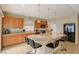 Bright kitchen featuring an island with granite countertop and seating and wooden cabinetry at 4535 Mission Meadow Cir, Las Vegas, NV 89139