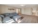 Cozy living room with a large gray sectional, neutral walls, and a view of the stairs at 4535 Mission Meadow Cir, Las Vegas, NV 89139