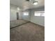 Empty bedroom with carpet, mirrored wall, and natural light from a window at 4560 Rancho Hills Dr, Las Vegas, NV 89119