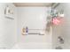 A clean white tiled shower and tub showcasing built-in shelving for bath products at 4648 Krissylouise Way, Las Vegas, NV 89121