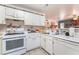 Functional kitchen features white appliances and bright white cabinets at 4648 Krissylouise Way, Las Vegas, NV 89121