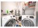 Functional laundry room with side-by-side washer and dryer, and built-in shelving for storage at 4648 Krissylouise Way, Las Vegas, NV 89121