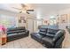 Open-concept living room featuring tile flooring, ceiling fans, and black sofas at 4648 Krissylouise Way, Las Vegas, NV 89121