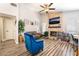 Bright open living room with fireplace, ceiling fan, and gray flooring, creating a great gathering space at 4648 Krissylouise Way, Las Vegas, NV 89121