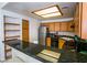 Galley kitchen with stainless steel refrigerator, black appliances, breakfast bar, and light wood cabinets at 4655 Gold Dust Ave # 206, Las Vegas, NV 89120