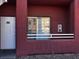 Exterior view of a unit with a white front door, a red frame, and a window reflecting the complex at 4730 E Craig Rd # 1148, Las Vegas, NV 89115