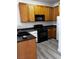 Well-equipped kitchen features wood cabinets, black appliances, black countertops, and stylish flooring at 4730 E Craig Rd # 1148, Las Vegas, NV 89115