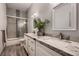 Bright bathroom with double sink vanity with granite counters, plant, and glass enclosed shower at 4740 W Agate Ave, Las Vegas, NV 89139