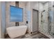 Bright and airy bathroom features modern tub, tiled walls, and a glass enclosed shower at 4740 W Agate Ave, Las Vegas, NV 89139