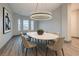 Bright dining room features a modern chandelier, a sleek table with seating for six, and natural light from bay windows at 4740 W Agate Ave, Las Vegas, NV 89139