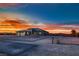 A single-story home showcases a modern exterior with stone accents and a three-car garage against a dramatic sunset at 4740 W Agate Ave, Las Vegas, NV 89139
