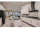 The open kitchen has an island with granite countertops, stainless steel appliances, and white cabinets at 4740 W Agate Ave, Las Vegas, NV 89139