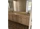 Double vanity with dated cabinets and large mirror, offering ample space and storage in a neutral-toned primary bathroom at 5024 Saint Annes Dr, Las Vegas, NV 89149