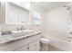 Bright white bathroom with a shower over tub, granite vanity, and light wood flooring at 5280 Shreve Ave, Las Vegas, NV 89156