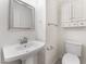 Small powder room includes a white pedestal sink, matching toilet, mirror and storage cabinet at 5280 Shreve Ave, Las Vegas, NV 89156