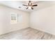 Bright bedroom with a window, ceiling fan, light walls, and wood flooring at 5280 Shreve Ave, Las Vegas, NV 89156
