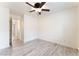 An airy bedroom featuring hardwood flooring, a ceiling fan with lighting, and a connecting hall way at 5280 Shreve Ave, Las Vegas, NV 89156