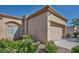 Tan stucco home with a two-car garage featuring a desert landscaped front yard at 5280 Shreve Ave, Las Vegas, NV 89156