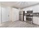Bright kitchen featuring stainless steel appliances, white cabinets, a pantry and light wood flooring at 5280 Shreve Ave, Las Vegas, NV 89156
