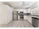 A bright kitchen is equipped with stainless steel appliances, white cabinets, and gray subway tile backsplash at 5280 Shreve Ave, Las Vegas, NV 89156