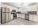A well-lit kitchen with stainless steel appliances, gray subway tile backsplash and light wood flooring at 5280 Shreve Ave, Las Vegas, NV 89156