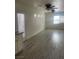 Open concept living room with light colored floors, white trim, and a ceiling fan at 5280 Shreve Ave, Las Vegas, NV 89156