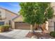Charming home exterior with a well-maintained lawn, mature trees, and a two-car garage at 5452 Tinker Toy Ave, Las Vegas, NV 89139